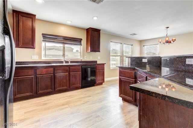 kitchen featuring dishwasher, an inviting chandelier, sink, light hardwood / wood-style flooring, and stainless steel fridge