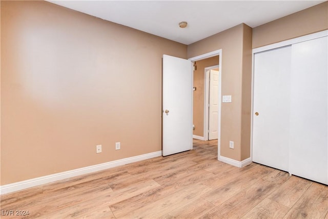 unfurnished bedroom featuring a closet and light hardwood / wood-style flooring