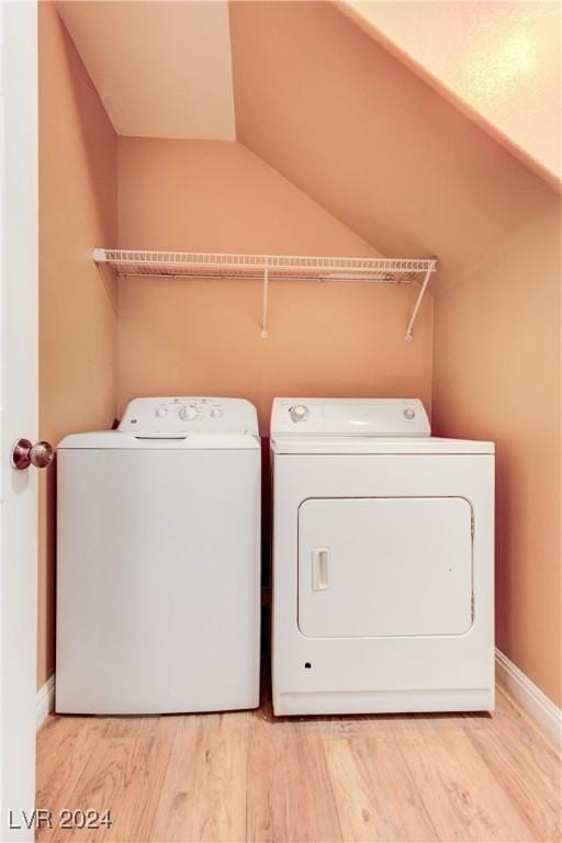 laundry area with light wood-type flooring and separate washer and dryer