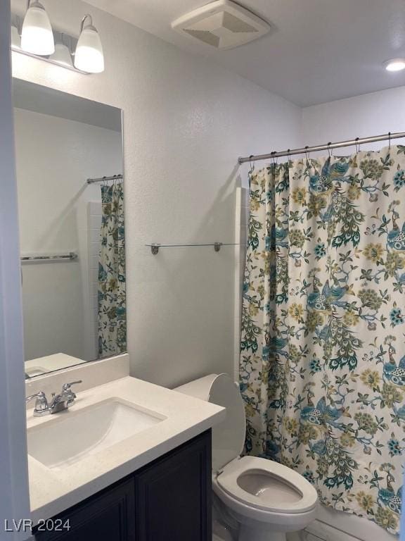 bathroom with vanity, curtained shower, and toilet