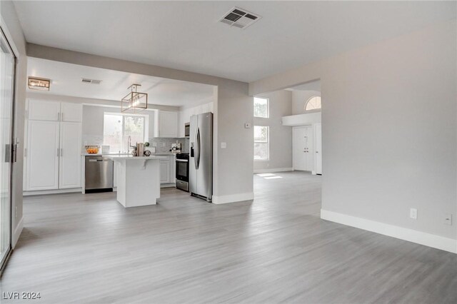 kitchen featuring a center island, stainless steel appliances, plenty of natural light, and light hardwood / wood-style floors