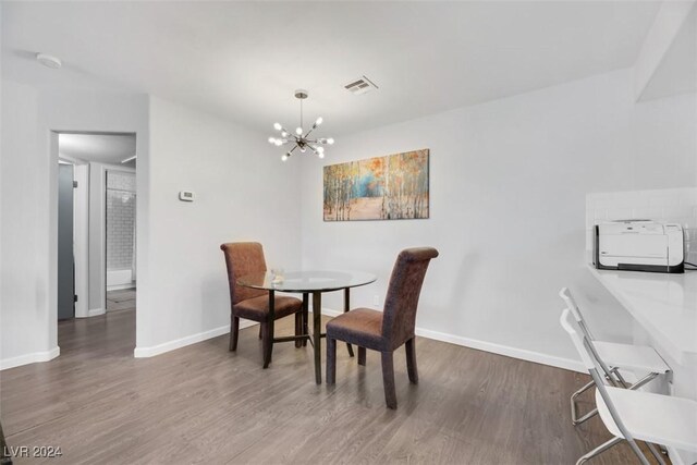 dining space featuring dark hardwood / wood-style flooring and a chandelier