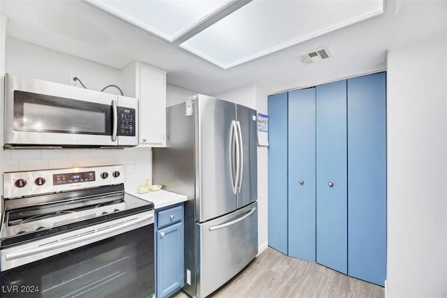 kitchen featuring backsplash, light hardwood / wood-style floors, blue cabinetry, and appliances with stainless steel finishes