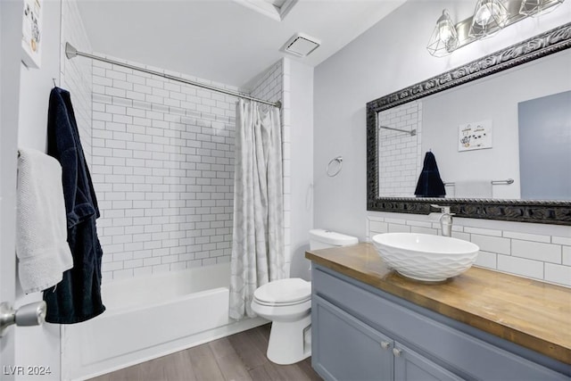 full bathroom with vanity, toilet, tasteful backsplash, wood-type flooring, and shower / tub combo