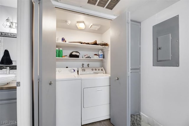 laundry room with separate washer and dryer, wood-type flooring, electric panel, and sink