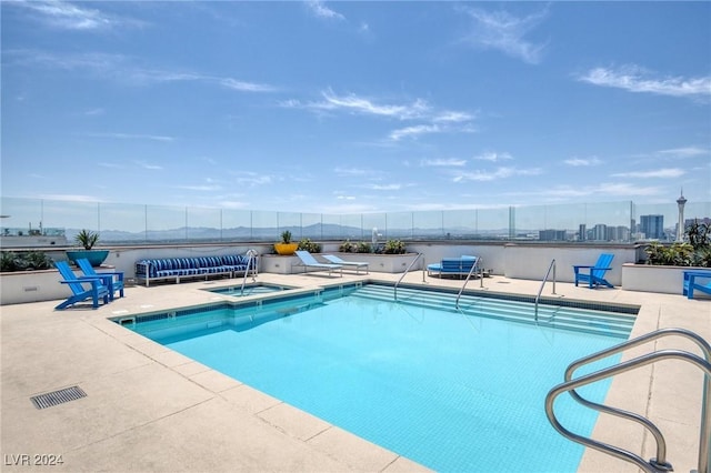 view of pool with a mountain view, a hot tub, and a patio area