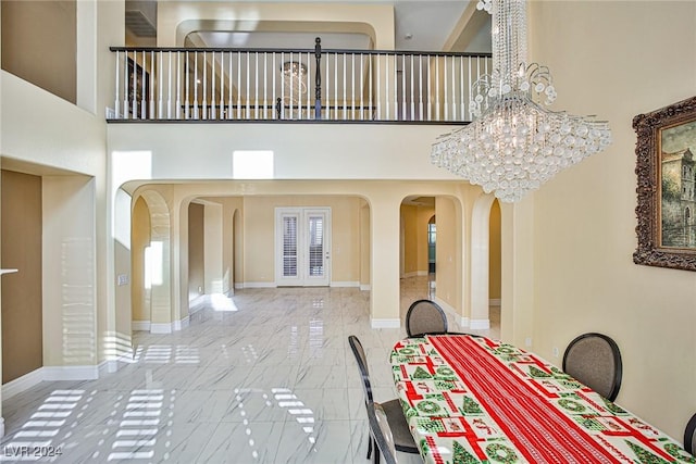 dining space featuring a high ceiling and a chandelier