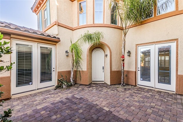 view of exterior entry with a patio and french doors