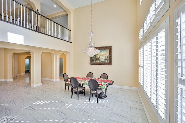 dining room with a high ceiling and an inviting chandelier