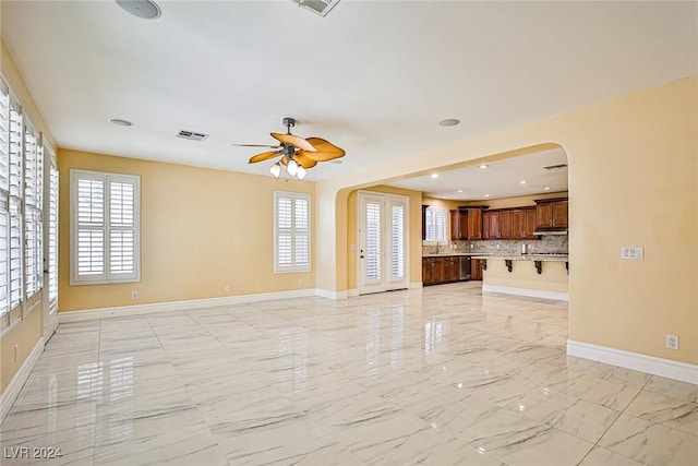 unfurnished living room with ceiling fan