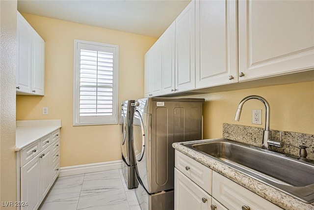 laundry area featuring washer and clothes dryer, cabinets, and sink