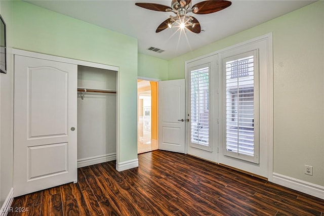 unfurnished bedroom with ceiling fan, dark hardwood / wood-style flooring, and a closet