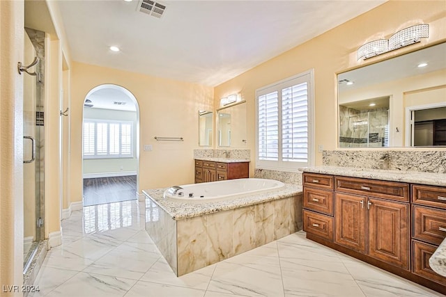 bathroom with vanity and shower with separate bathtub