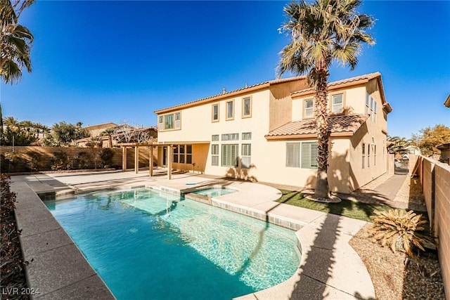 back of house featuring a pergola, a swimming pool with hot tub, and a patio