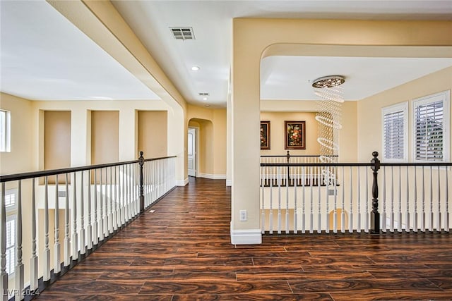 hall featuring dark hardwood / wood-style flooring and a notable chandelier