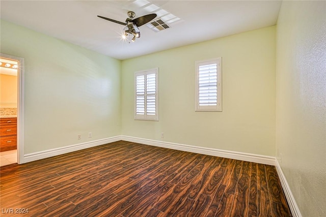 empty room with ceiling fan and dark hardwood / wood-style flooring