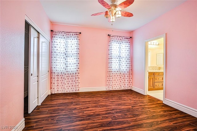 unfurnished bedroom featuring multiple windows, ceiling fan, and dark hardwood / wood-style floors