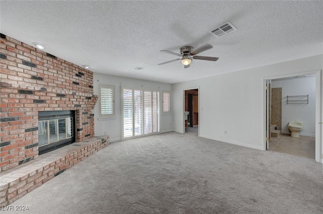 unfurnished living room featuring light carpet, a textured ceiling, and a fireplace