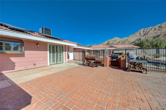 view of patio with central air condition unit, area for grilling, and a mountain view