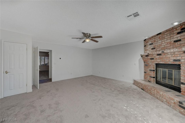 unfurnished living room with light carpet, a fireplace, ceiling fan, and a textured ceiling