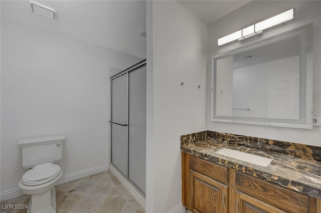 bathroom featuring vanity, toilet, and an enclosed shower