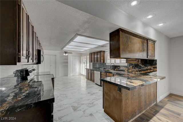 kitchen with kitchen peninsula, appliances with stainless steel finishes, backsplash, a textured ceiling, and ceiling fan