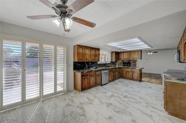 kitchen featuring a textured ceiling, ceiling fan, backsplash, and appliances with stainless steel finishes