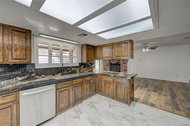 kitchen with kitchen peninsula, tasteful backsplash, sink, light hardwood / wood-style flooring, and dishwasher