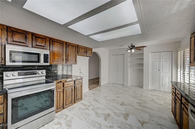 kitchen featuring stainless steel electric stove, ceiling fan, backsplash, and a textured ceiling