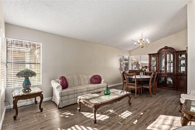 living room featuring a textured ceiling, a notable chandelier, lofted ceiling, and dark wood-type flooring