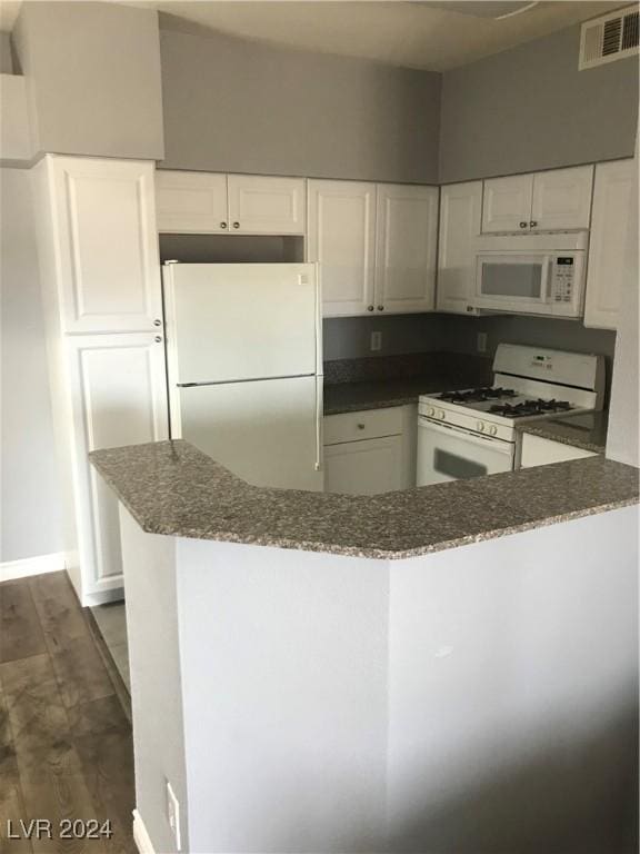 kitchen featuring white cabinets, dark hardwood / wood-style flooring, white appliances, and kitchen peninsula