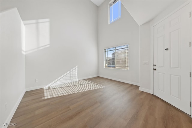 entrance foyer with hardwood / wood-style floors and high vaulted ceiling