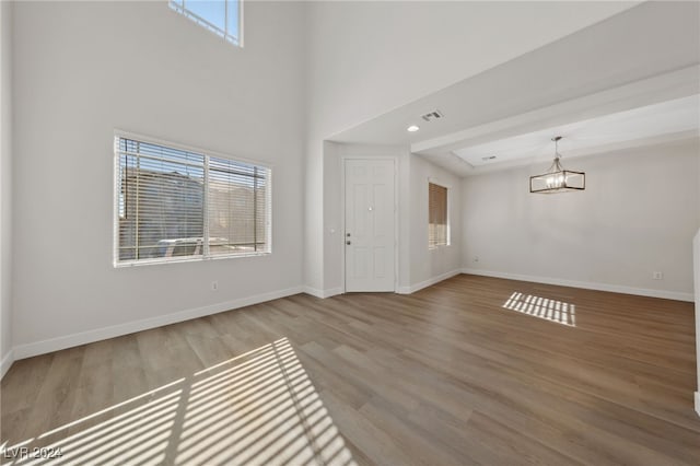 unfurnished living room featuring hardwood / wood-style floors and a notable chandelier