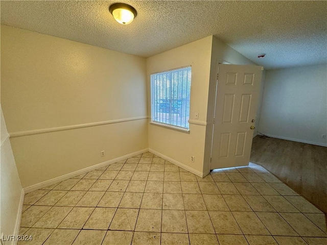 unfurnished room with a textured ceiling