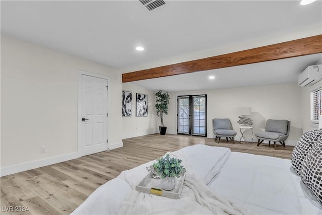 bedroom with beam ceiling, an AC wall unit, french doors, and light hardwood / wood-style flooring