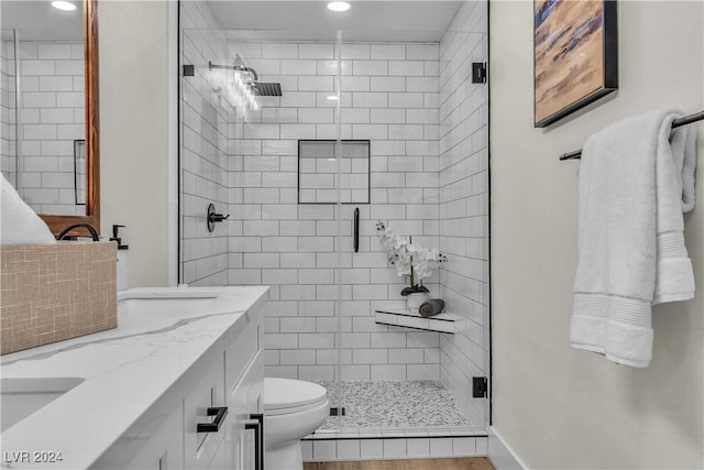 bathroom with hardwood / wood-style floors, vanity, an enclosed shower, and toilet