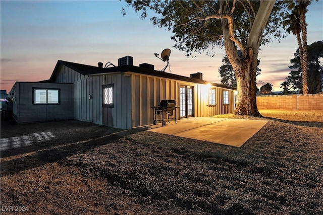 back house at dusk with a patio