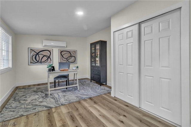 office featuring light hardwood / wood-style flooring and a wall mounted AC