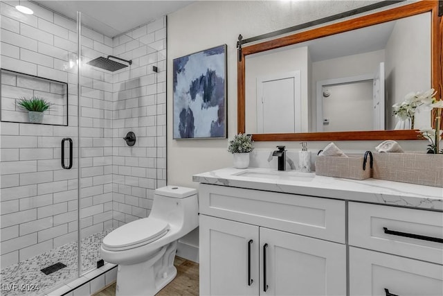 bathroom with an enclosed shower, vanity, and toilet