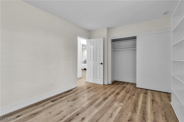 unfurnished bedroom featuring light hardwood / wood-style flooring and a closet