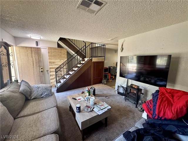 living room featuring carpet flooring, a wood stove, and a textured ceiling