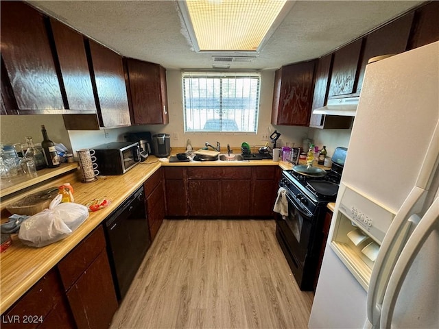 kitchen featuring dark brown cabinetry, sink, light hardwood / wood-style flooring, a textured ceiling, and black appliances