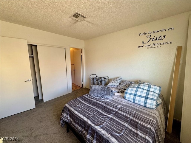 carpeted bedroom featuring a closet and a textured ceiling