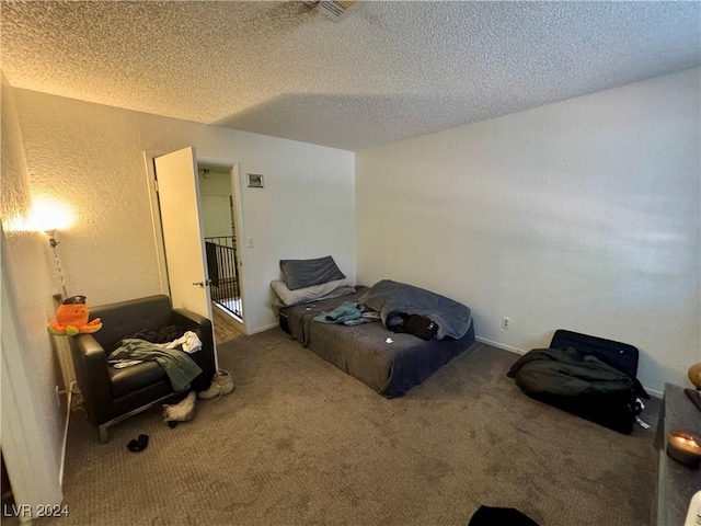 bedroom with carpet floors and a textured ceiling