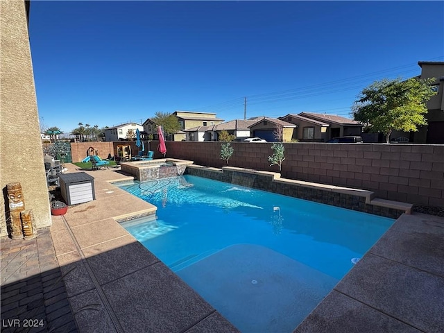 view of swimming pool featuring an in ground hot tub, pool water feature, and a patio