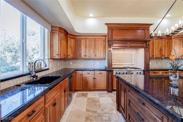 kitchen featuring appliances with stainless steel finishes, dark stone counters, a healthy amount of sunlight, and sink