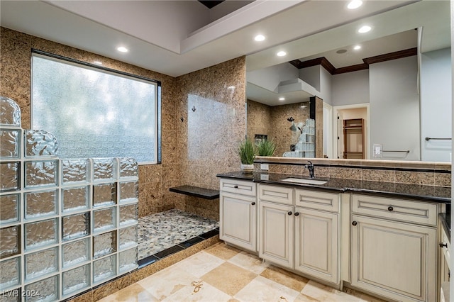 bathroom with vanity, ornamental molding, tile walls, and walk in shower