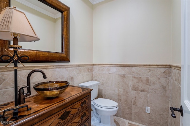 bathroom featuring crown molding, vanity, tile walls, and toilet