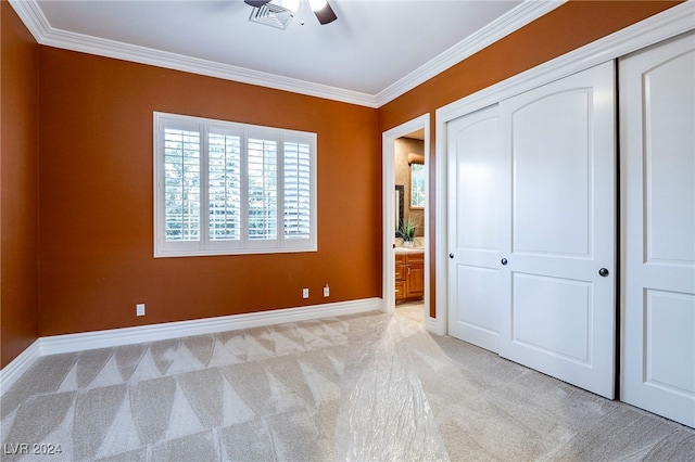 unfurnished bedroom featuring light carpet, ceiling fan, and crown molding