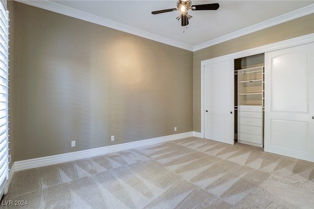 unfurnished bedroom with ceiling fan, light colored carpet, crown molding, and a closet